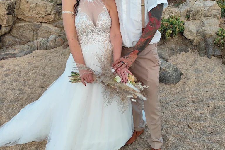 die Hände des Brautpaares ruhen auf dem Brautstrauß, Strandhochzeit - meer sardinien urlaub