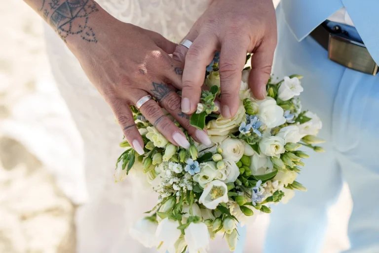 die Hände des Paares auf dem Brautstrauss, Strandhochzeit, meer sardinien urlaub