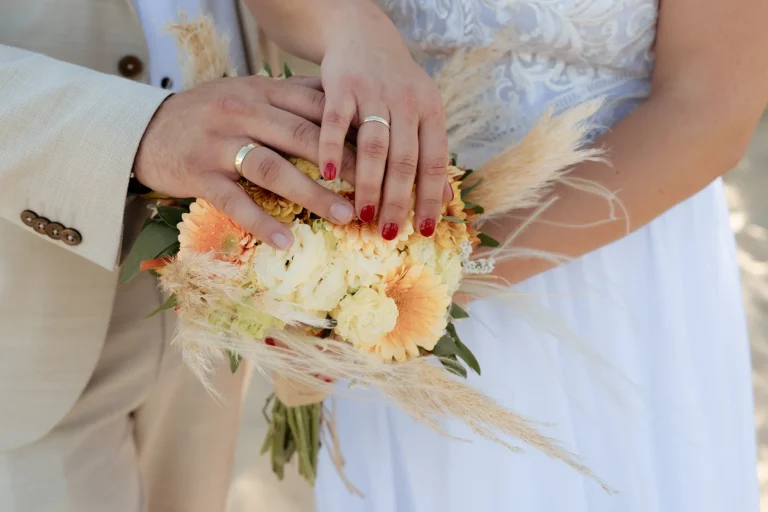 die Hände des Paares über dem Strauß, Strandhochzeit - meer sardinien urlaub