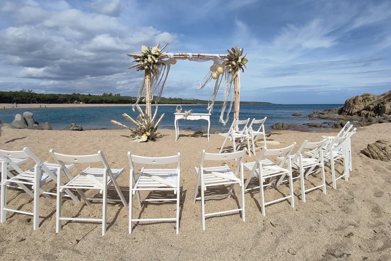 die Stühle der Gäste umarmen symbolisch das Brautpaar, Strandhochzeit mit Küstenturm - meer sardinien urlaub