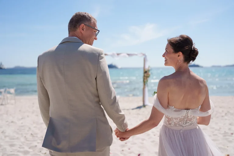 glücklich lächelt sich das Brautpaar an, Strandhochzeit, meer sardinien urlaub