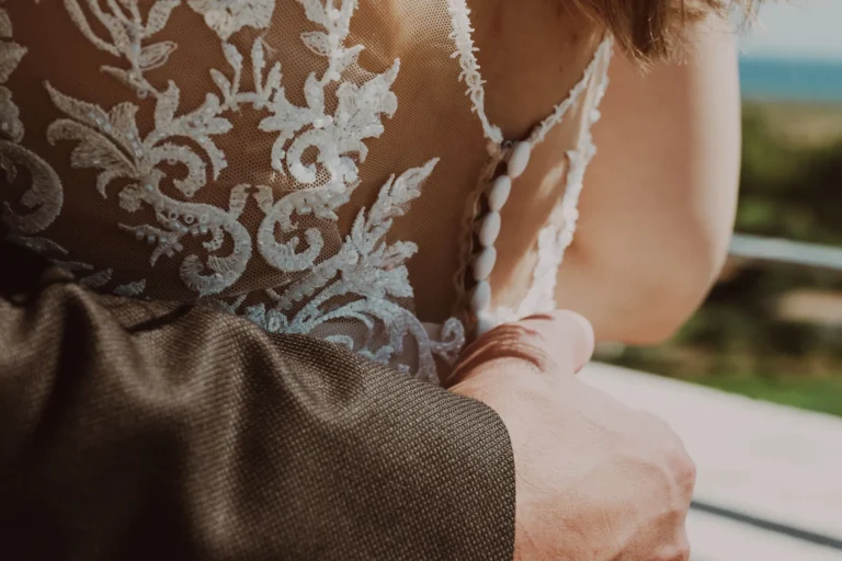 sanft umfasst der Bräutigam die Taille seiner Braut nach der Hochzeit auf dem Standesamt - meer sardinien urlaub