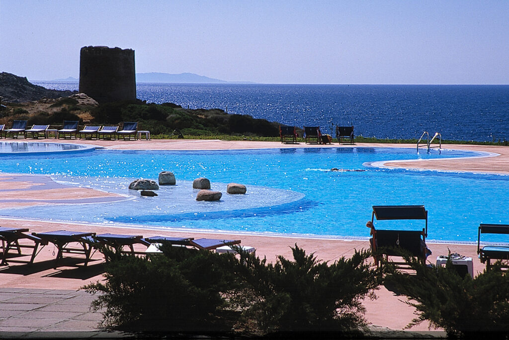 Der harmonisch geschwungene Pool mit Sarazenenturm beim Hotel Relax Thalasso & Spa Torreruja, Isola Rossa - meer sardinien urlaub
