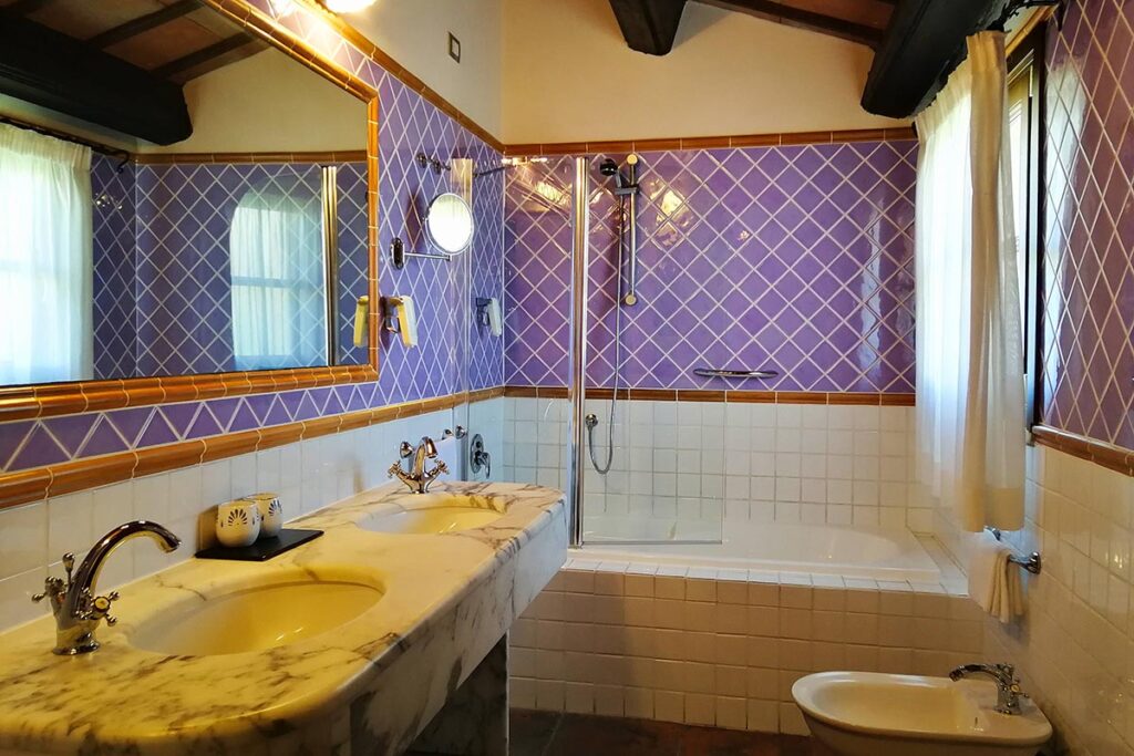 Bad mit Badewanne eines Dreibettzimmers im Hotel Il Vecchio Mulino, Arbatax bei Tortoli - meer sardinien urlaub