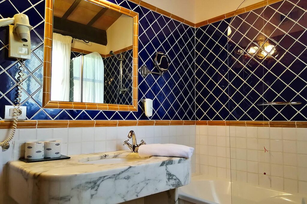 das Bad eines Dreibettzimmers mit Badewanne im Hotel Il Vecchio Mulino, Arbatax bei Tortoli - meer sardinien urlaub