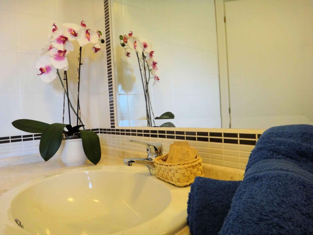 Waschbecken mit Spiegelwand in einem Badezimmer des Hotels Tartaruga Bianca, La Ciaccia-Valledoria - meer sardinien urlaub