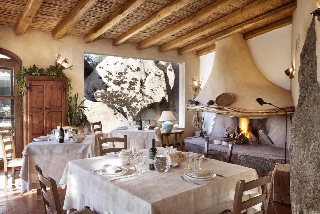 der Restaurantsaal mit Kamin im Hotel Resort Tenuta Pilastru, Arzachena - meer sardinien urlaub