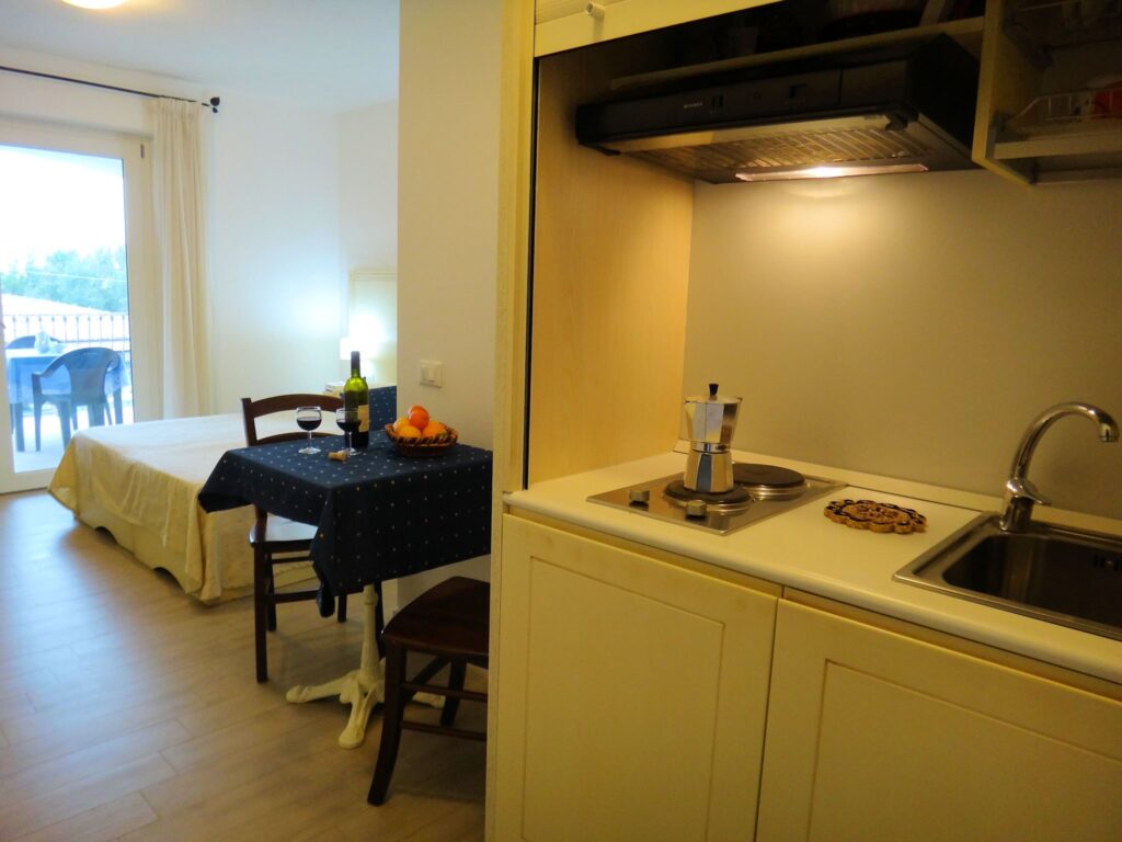 der Schlafraum mit Essbereich und geoeffnetem Kuechenschrank zur Nutzung als Ein-Zimmer-Wohnung, Hotel Tartaruga Bianca, La Ciaccia-Valledoria - meer sardinien urlaub