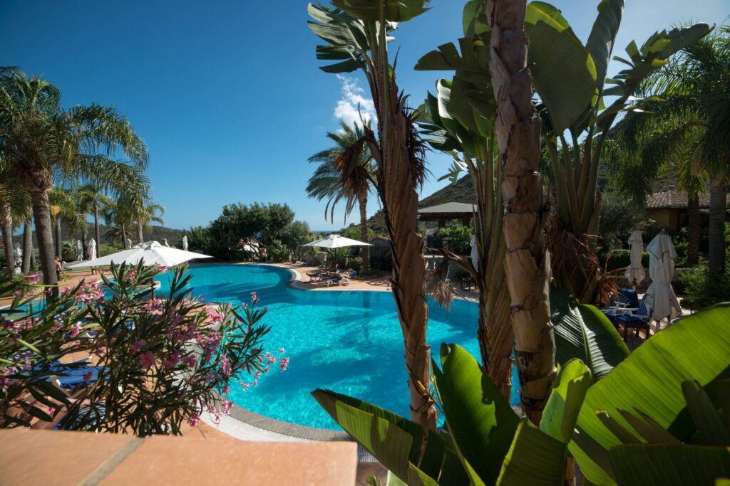 hohe Palmen am Pool, Hotel Cruccuris Resort, Villasimius - meer sardinien urlaub