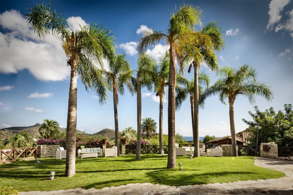stimmungsvolles Gartenbild mit Palmen, Hotel Cruccuris Resort, Villasimius - meer sardinien urlaub