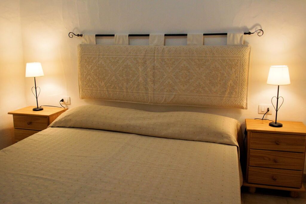 Ein Schlafzimmer in einem Ferienhaus Sa Fiorida - meer sardinien urlaub