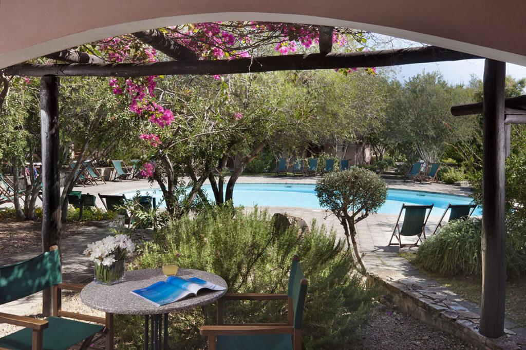 Eine Veranda mit Poolblick des Aparthotelsbereichs La Rotonda des Cala die Falco Resorts, Cannigione - meer sardinien urlaub