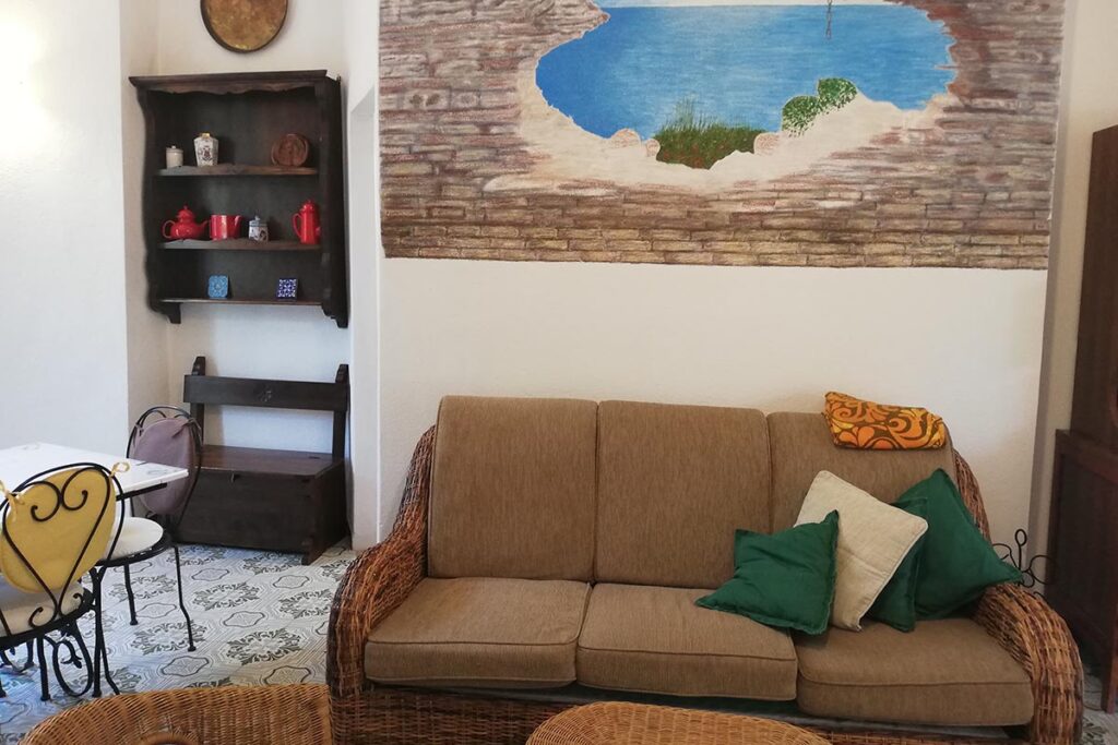 bemalte Wände schmücken das Wohnzimmer des Ferienhauses Mandara, Baccu Mandara - meer sardinien urlaub