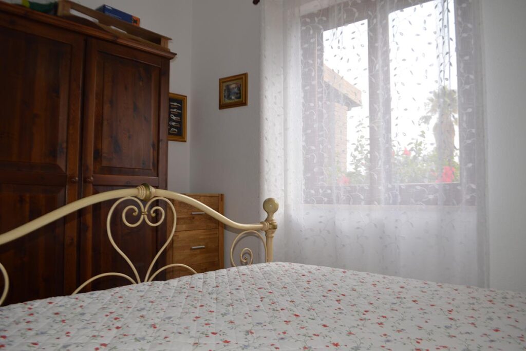 das Doppelbett-Schlafzimmer des Ferienhauses Cocco - meer sardinien urlaub
