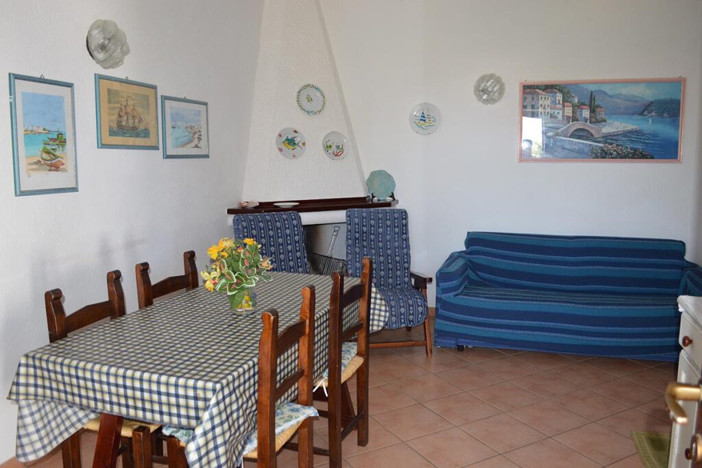 das Wohnzimmer mit Kamin und Schlafcouch des Ferienhauses Camboni in Costa Rei - meer sardinien urlaub