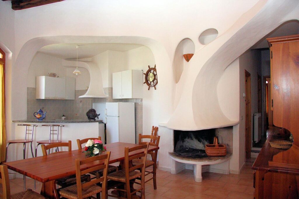 der Essraum mit Kamin und Kochecke des Ferienhaustyps Sa Fiorida - meer sardinien urlaub