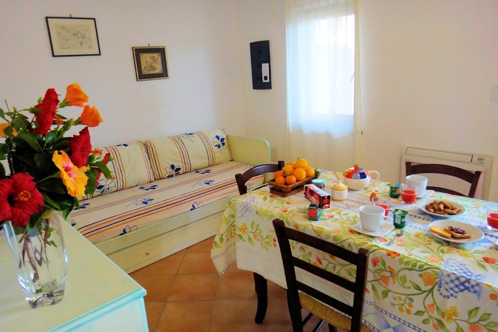 der Wohn- und Essbereich mit Schlafcouch einer Ferienwohnung Solevacanze - meer sardinien urlaub
