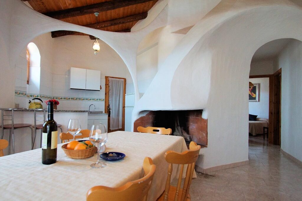 der Wohnraum mit Kamin eines Ferienhauses Sa Fiorida - meer sardinien urlaub