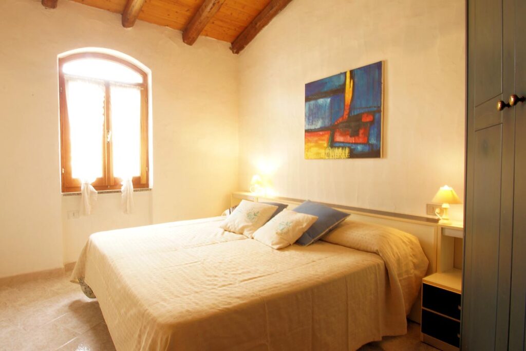 ein Doppelschlafzimmer eines Ferienhauses Sa Fiorida - meer sardinien urlaub