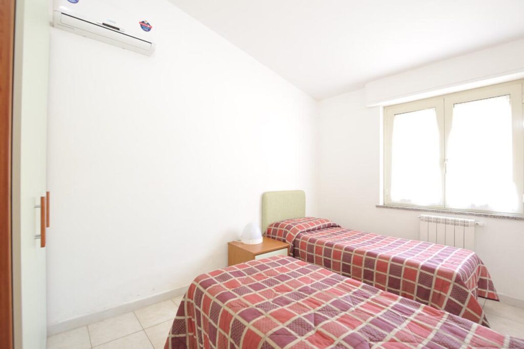 ein Schlafraum mit zwei Einzelbetten der Ferienwohnung Le Terrazze Quadri - meer sardinien urlaub