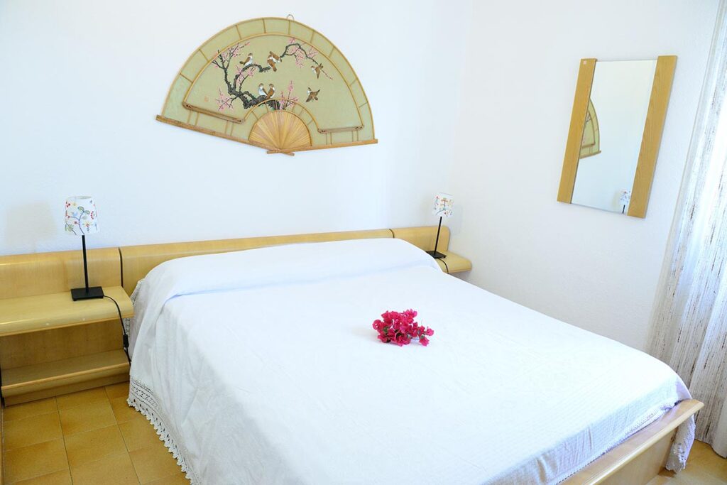 ein Schlafzimmer mit Doppelbett des Ferienhauses Borla in Costa Rei - meer sardinien urlaub