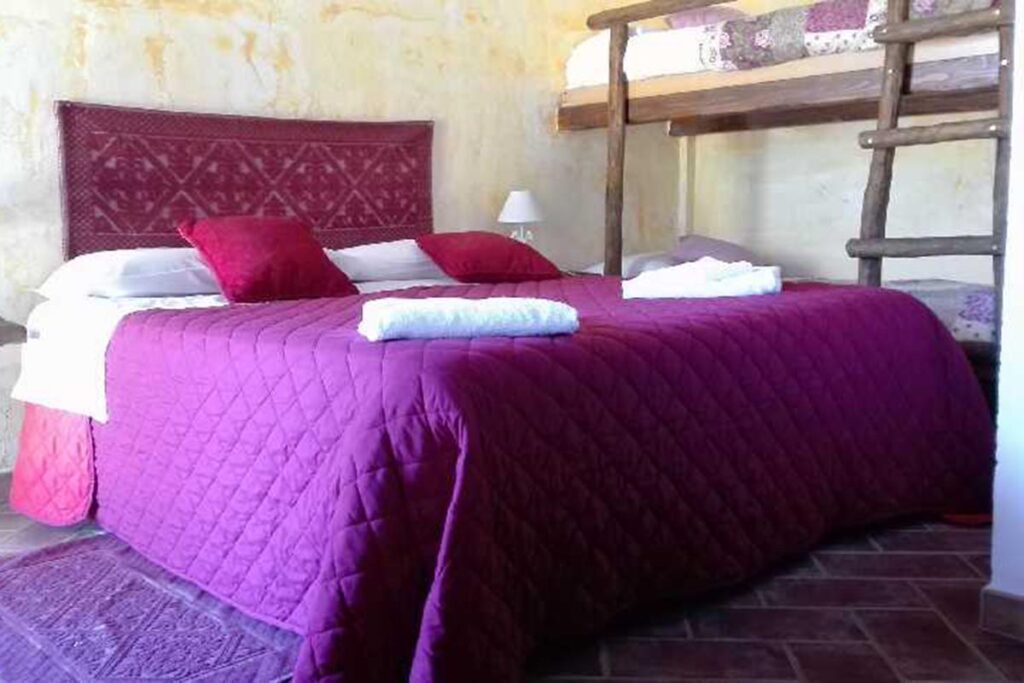 eines der individuell eingerichteten Schlafzimmer mit Doppel- und Etagenbett im Agriturismo Neule, Dorgali - meer sardinien urlaub