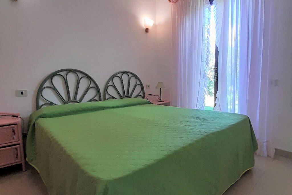 ein Schlafzimmer mit Doppelbett des Ferienhauses Vivi, Costa Rei - meer sardinien urlaub