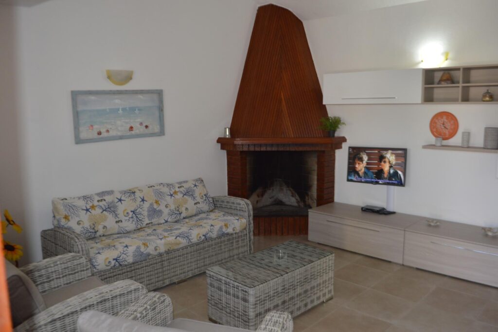 das Wohnzimmer mit Kamin im Ferienhaus Paluan, Costa Rei - meer sardinien urlaub