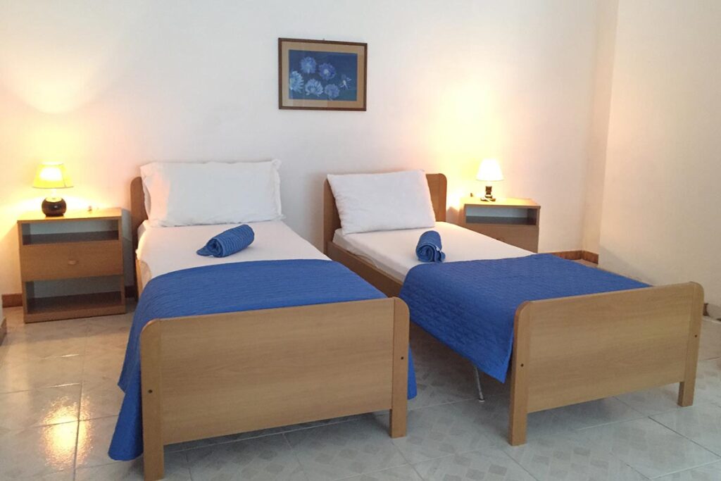 ein Schlafzimmer mit zwei Einzelbetten der Ferienwohnung Sabbia Bianca, Portixeddu - meer sardinien urlaub