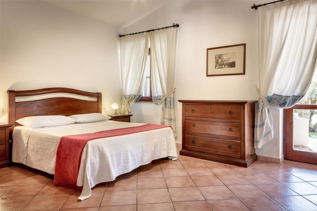 ein Schlafzimmer mit Doppelbett im Ferienhaus Ulivo, Alghero - meer sardinien urlaub