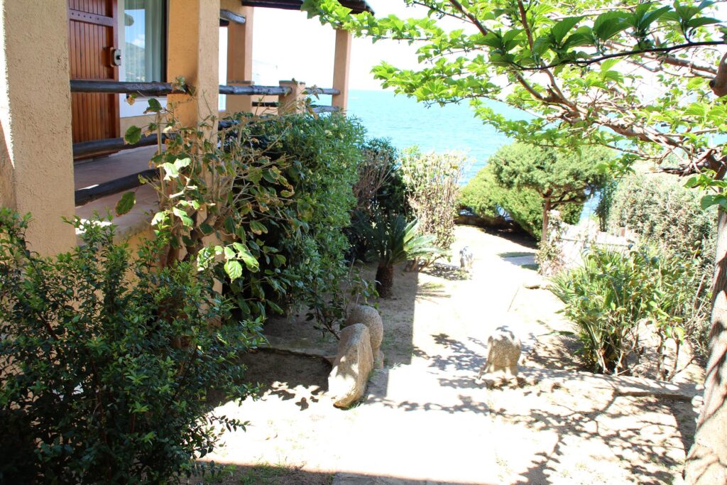 Der Aussenbereich an der Hausseite und das glitzernde Meer im Hintergrund, Ferienhaus Barbara, Torre delle Stelle - meer sardinien urlaub