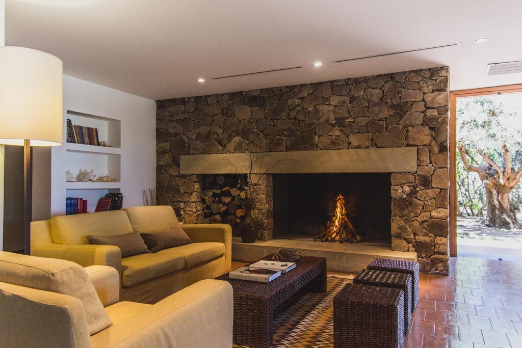 Der Sitzbereich mit Kamin in der Hall des Hotels Aquadulci, Chia - meer sardinien urlaub