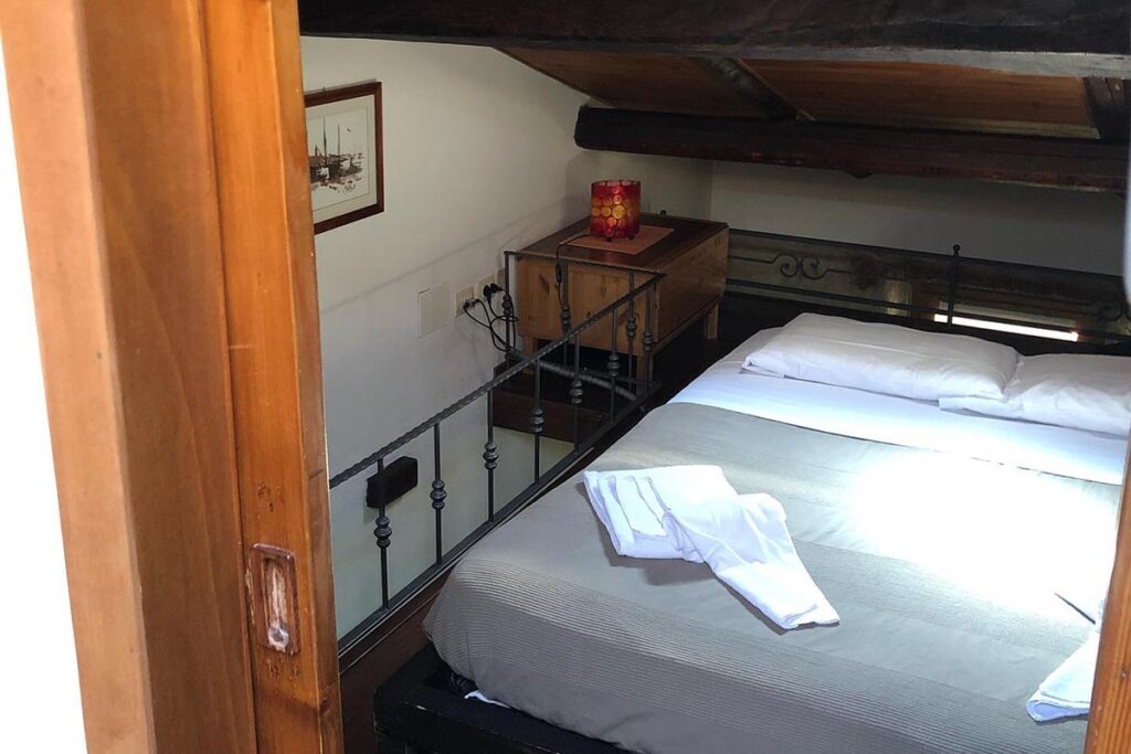 Ein Doppelbett auf der Zwischenetage mit Schrägdach, BB Aigua in Alghero - meer sardinien urlaub