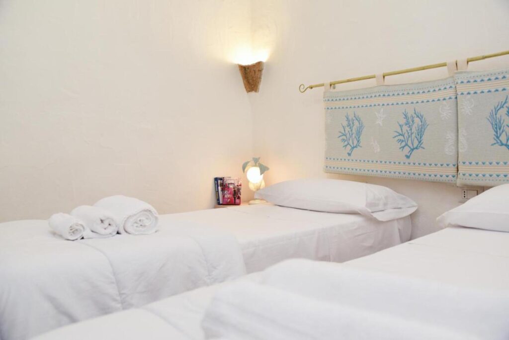 Ein Schlafzimmer mit zwei zusammenstellbaren Einzelbetten im Ferienhaus Barbara, Torre delle Stelle - meer sardinien urlaub