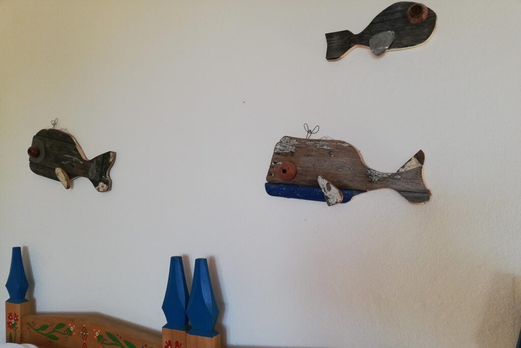 Kunstvolle Holzfische an einre Schlafzimmerwand, Ferienhaus Rubino, Torre delle Stelle - meer sardinien urlaub