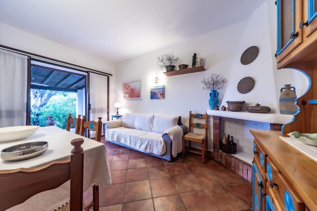 der Wohnraum mit Kamin des Ferienhauses Nicola, Costa Rei - meer sardinien urlaub