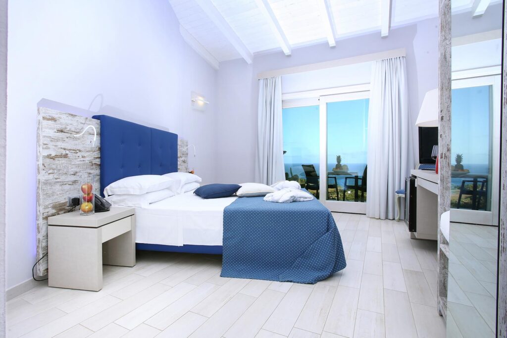 Blick über die Juniorsuite zur Glastür mit Meerblick, Hotel Bajaloglia, Castelsardo - meer sardinien urlaub