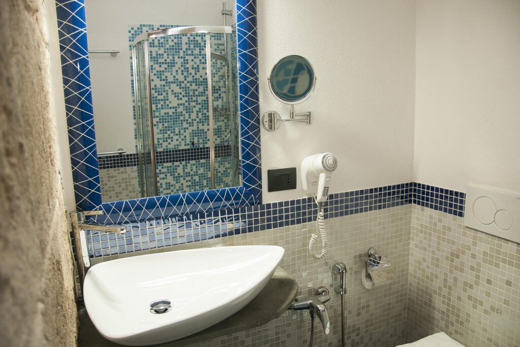 Das Bad mit Mosaik-Optik des Executive-Zimmers 102B, Hotel Maison de Charme Bienestar, Alghero - meer sardinien urlaub