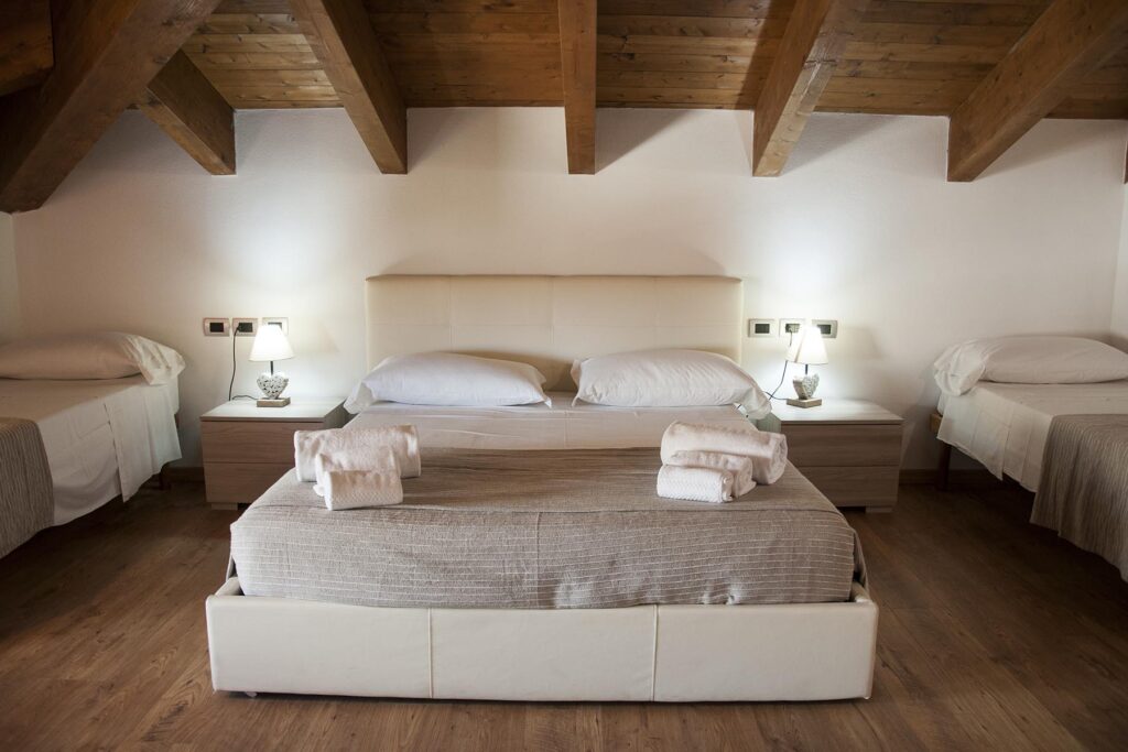 Das Familienzimmer 303 mit einem Doppel- und zwei Einzelbetten, Hotel Maison de Charme Bienestar, Alghero - meer sardinien urlaub