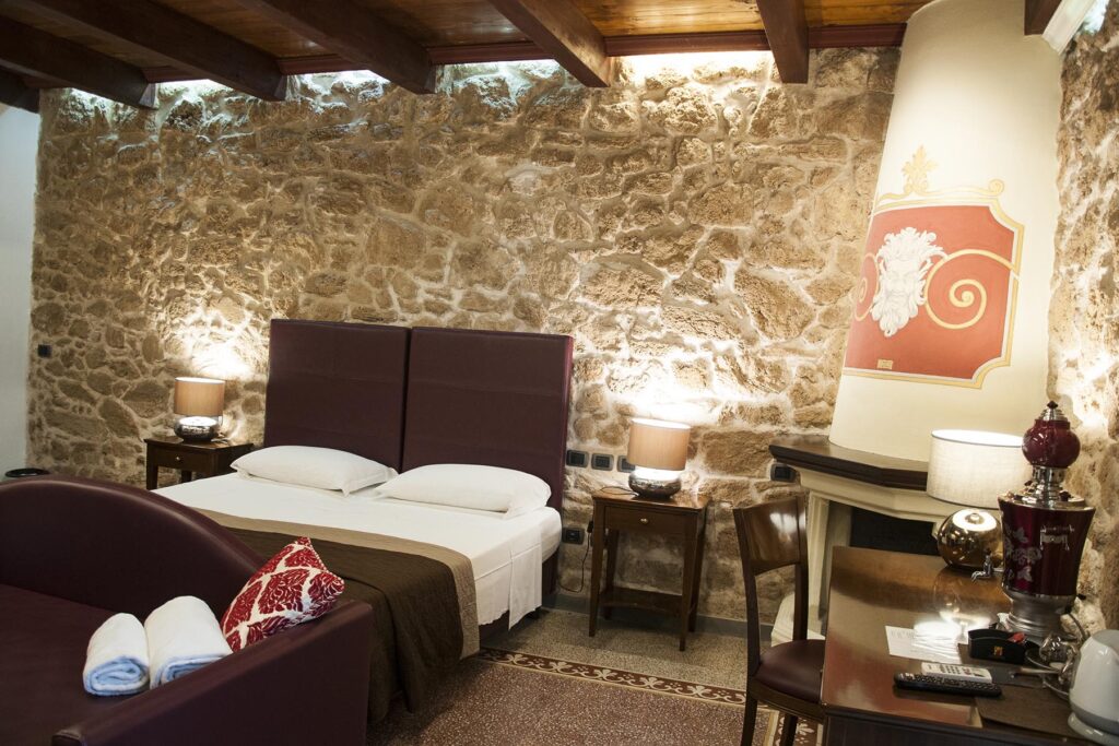 Die Juniorsuite Prestige 101 bietet Hydrowanne und einen dekorativen Kamin im Zimmer, Hotel Maison de Charme Bienestar, Alghero - meer sardinien urlaub