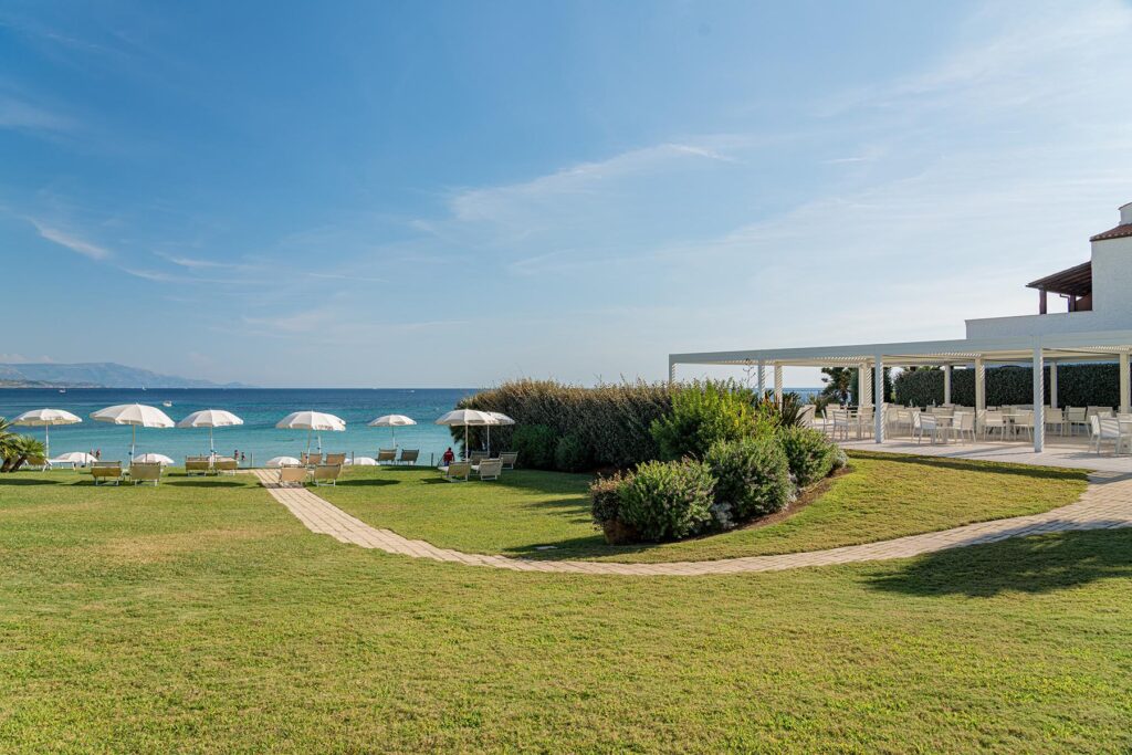 der Rasen und der angrenzende Strand im Hotel Punta Negra, Alghero - meer sardinien urlaub