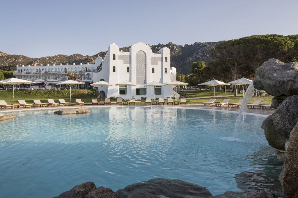 Der weite Pool mit dem Hotelgebäude im Hintergrund vom Hotel Falkensteiner Capo Boi bei Villasimius - meer sardinien urlaub