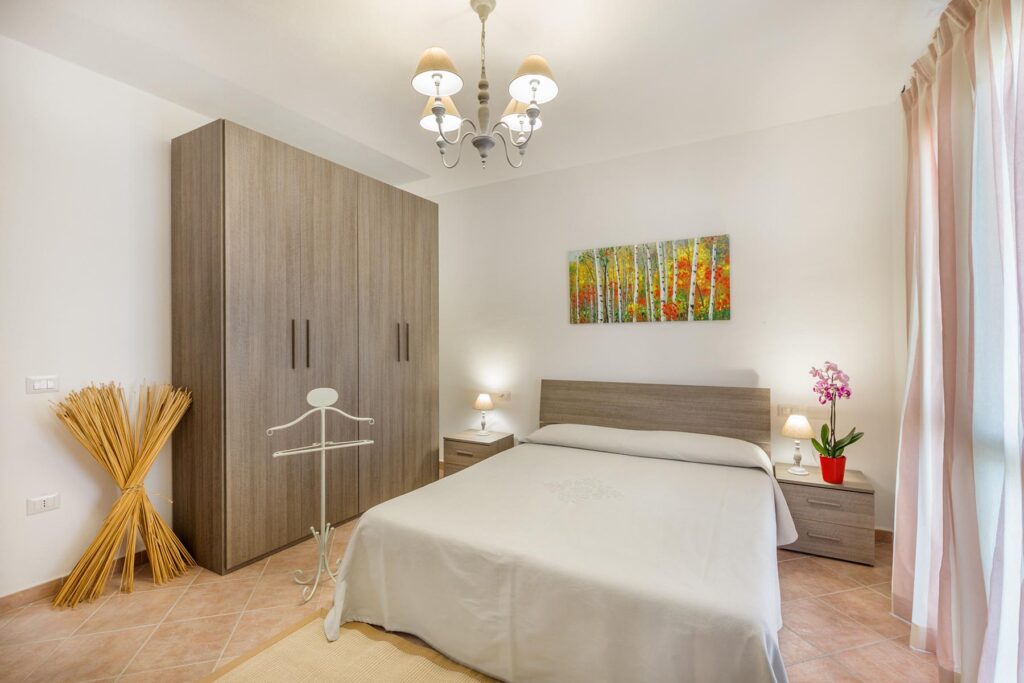 Ein Schlafzimmer des Grand Apartment im Nebengebäude Loft und Apartments, Hotel Mannois, Orosei