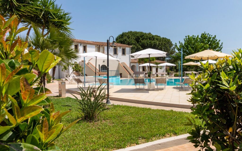 der Aussenbereich mit Pool und Blick auf die Wohngebäude des Aparthotels Museddu Beach, Cardedu - meer sardinien urlaub