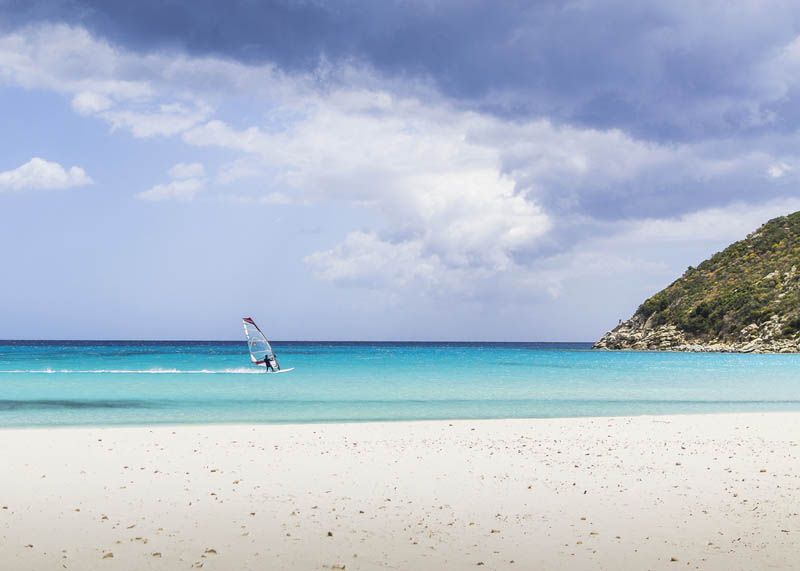 Ein Surfer am hellen Strand Poetto der Inselhauptstadt Cagliari, Südsardinien - meer sardinien urlaub